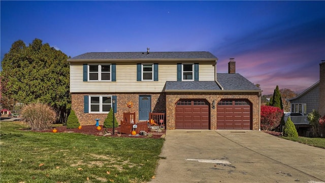 view of property featuring a lawn and a garage