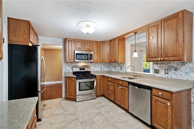 kitchen with sink, decorative light fixtures, stainless steel appliances, and backsplash