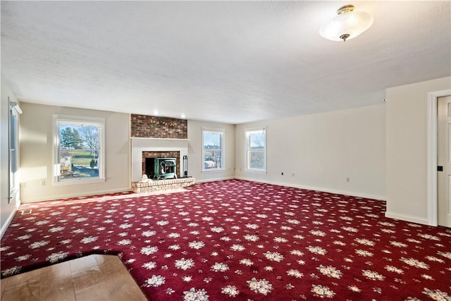 unfurnished living room featuring a fireplace, carpet floors, and a textured ceiling