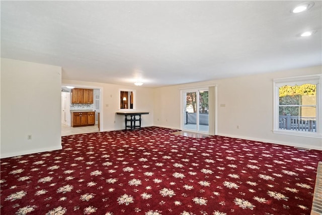 unfurnished living room featuring light carpet