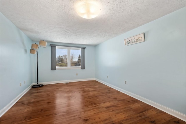 unfurnished room featuring hardwood / wood-style flooring and a textured ceiling