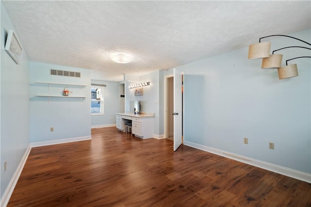 unfurnished living room featuring hardwood / wood-style floors and a textured ceiling