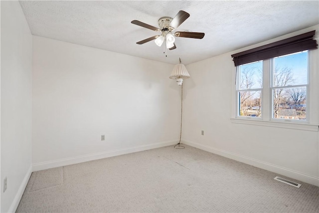 carpeted empty room featuring ceiling fan and a textured ceiling