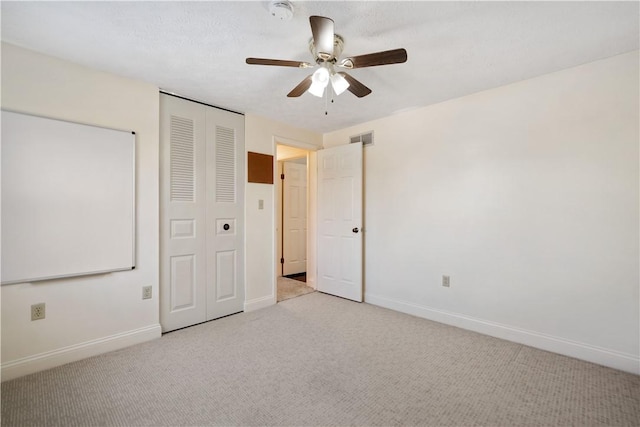 unfurnished bedroom with ceiling fan, light colored carpet, and a closet