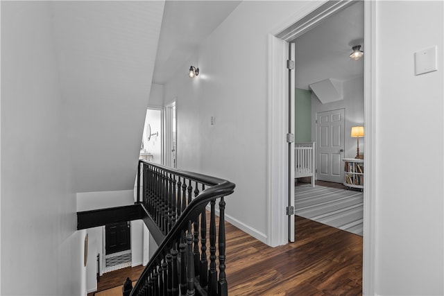 hallway featuring dark wood-type flooring and vaulted ceiling