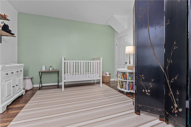 bedroom featuring a nursery area and wood-type flooring