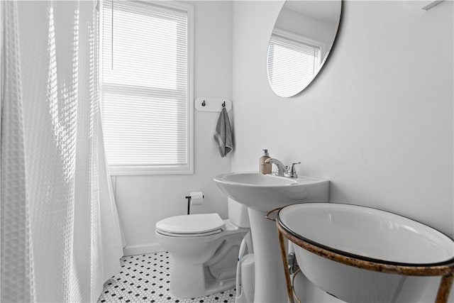 bathroom with walk in shower, a healthy amount of sunlight, and toilet