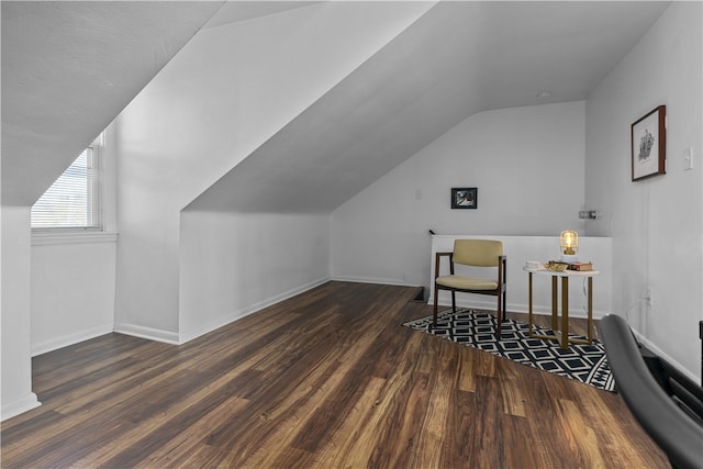 additional living space with dark hardwood / wood-style floors and vaulted ceiling