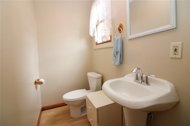 bathroom featuring hardwood / wood-style floors and toilet