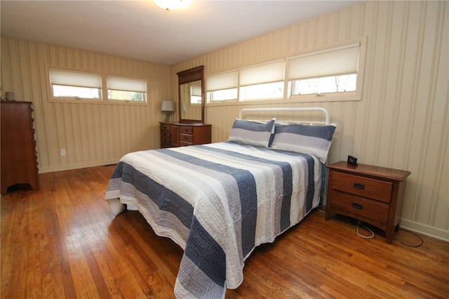 bedroom featuring multiple windows and dark hardwood / wood-style floors