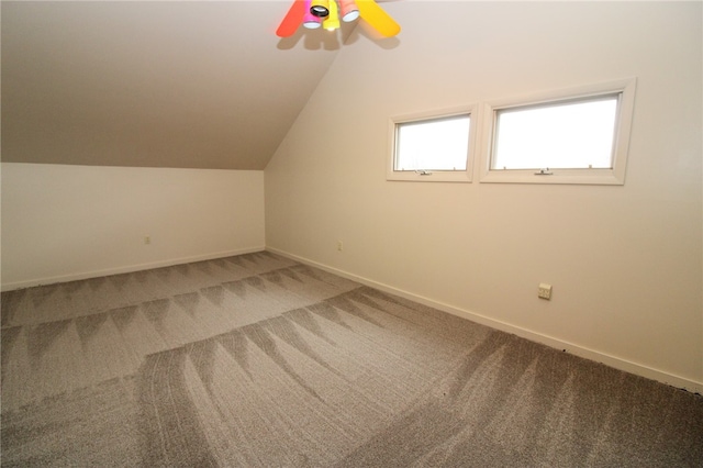 additional living space with vaulted ceiling and carpet flooring