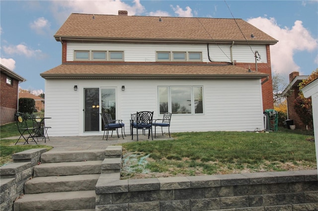 back of property with a lawn and a patio