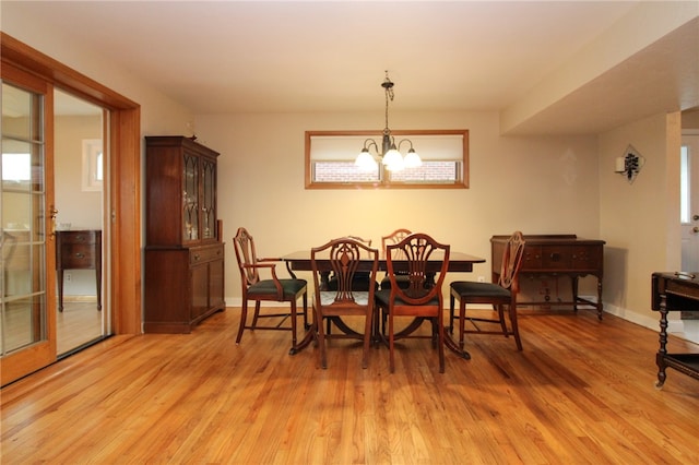 dining area with a wealth of natural light, a chandelier, and light hardwood / wood-style flooring