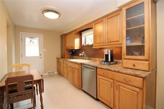 kitchen with dishwasher, sink, and light stone counters