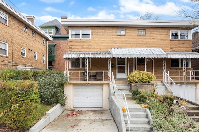 view of property featuring a garage and covered porch