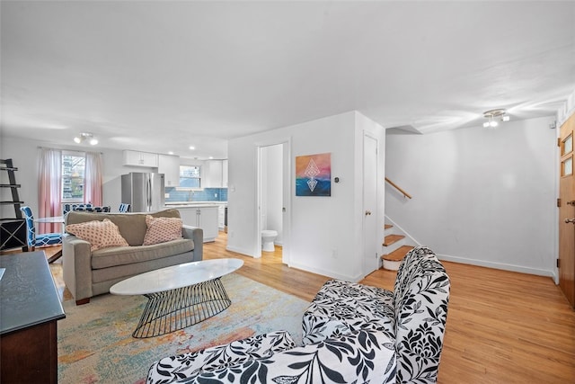 living room with light hardwood / wood-style floors and sink