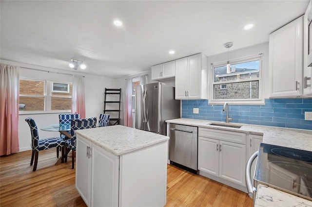 kitchen featuring stainless steel appliances, white cabinets, sink, and light wood-type flooring