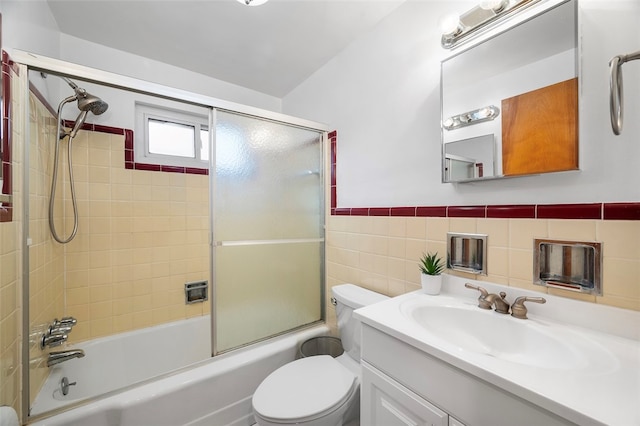 full bathroom featuring enclosed tub / shower combo, vanity, toilet, and tile walls