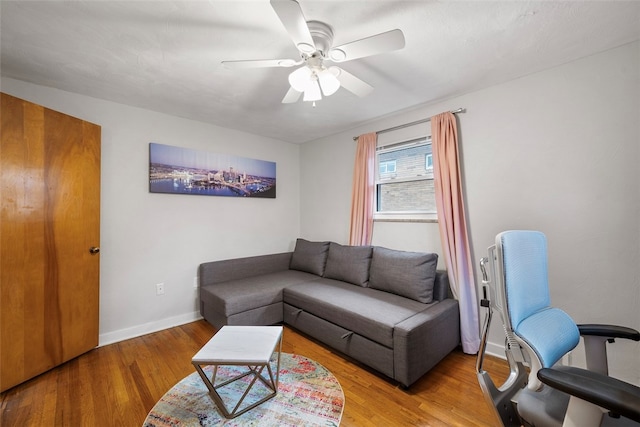 living room with ceiling fan and light hardwood / wood-style flooring