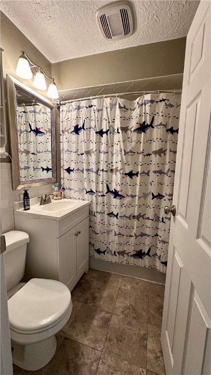 bathroom featuring vanity, a textured ceiling, toilet, and curtained shower