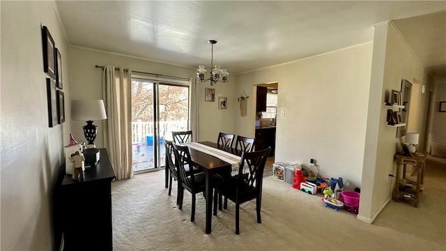 carpeted dining room with crown molding and an inviting chandelier