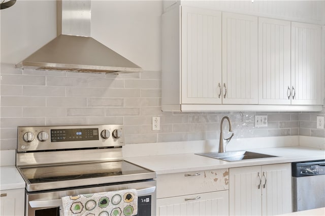 kitchen featuring appliances with stainless steel finishes, wall chimney exhaust hood, and white cabinets