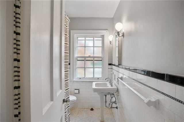 bathroom featuring tile walls, toilet, and tile patterned floors