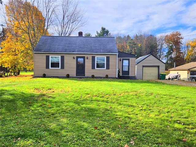 view of front of property featuring a garage, an outdoor structure, and a front yard