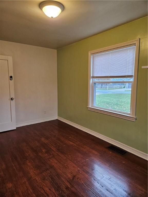 empty room with dark hardwood / wood-style floors