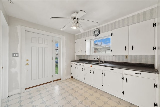 kitchen featuring white cabinets, ceiling fan, and sink