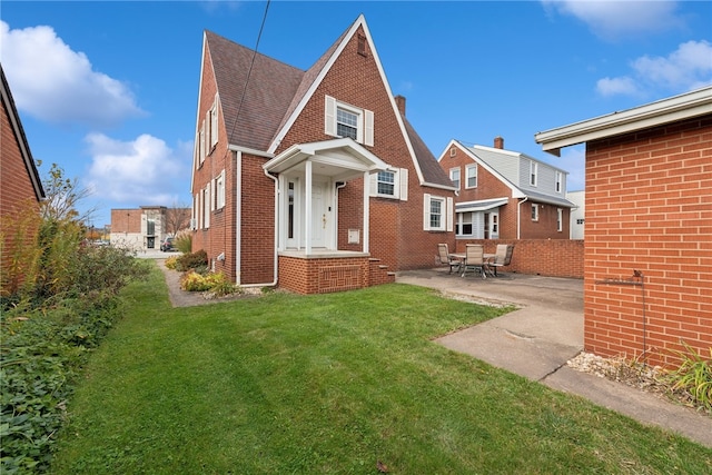 rear view of house featuring a patio and a lawn