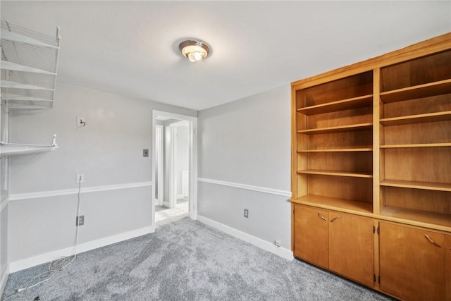 unfurnished room with light colored carpet and baseboards