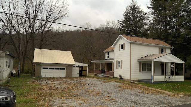 view of front of house with an outbuilding, a garage, and covered porch