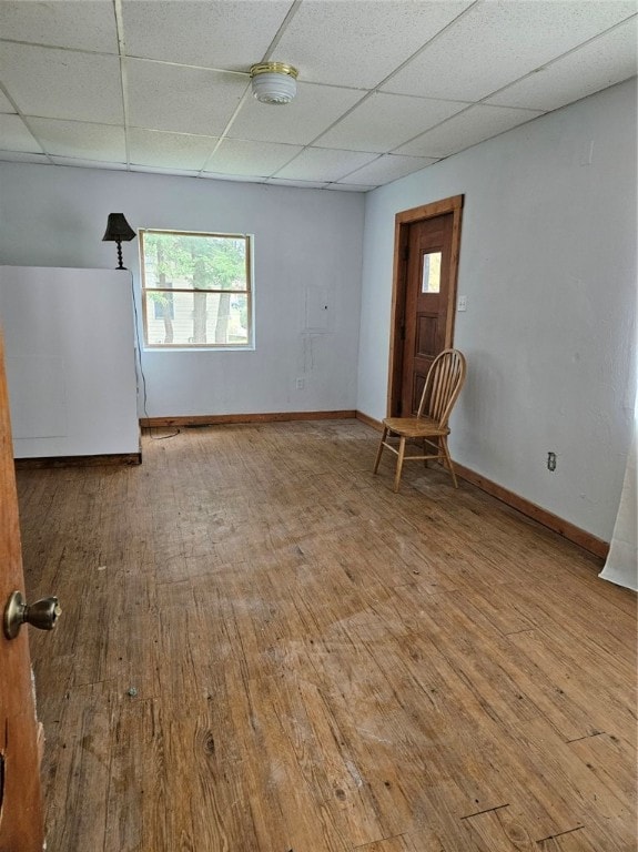 spare room with light hardwood / wood-style floors and a paneled ceiling