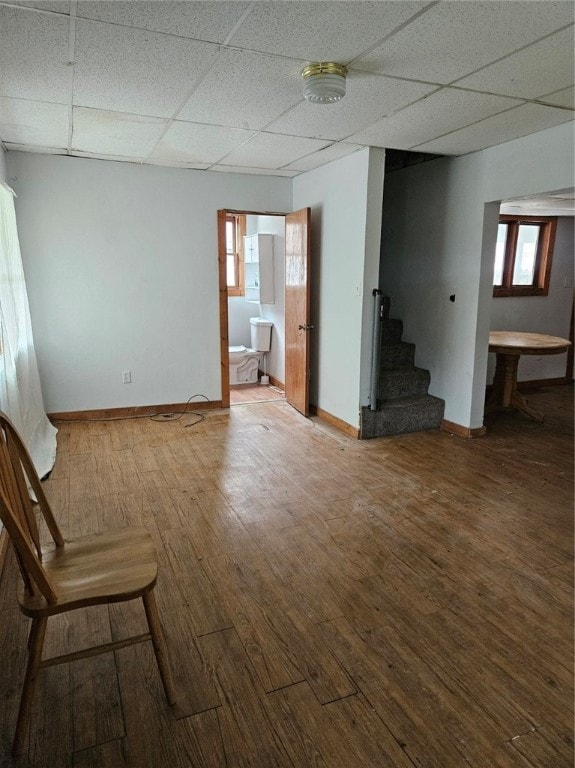 interior space with a paneled ceiling and wood-type flooring