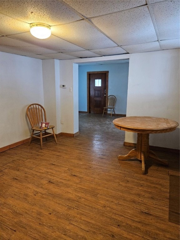 interior space with a drop ceiling and dark hardwood / wood-style floors