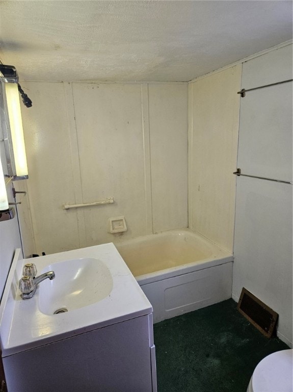 bathroom with toilet, vanity, and a textured ceiling