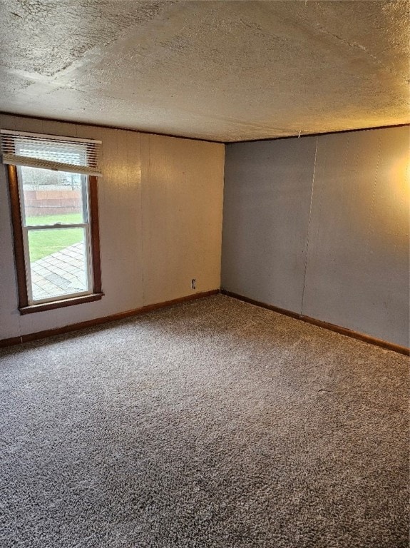 carpeted empty room featuring a textured ceiling