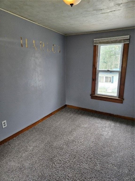 carpeted empty room with a textured ceiling