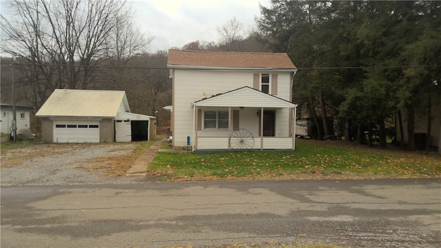 view of front facade featuring a garage and an outbuilding