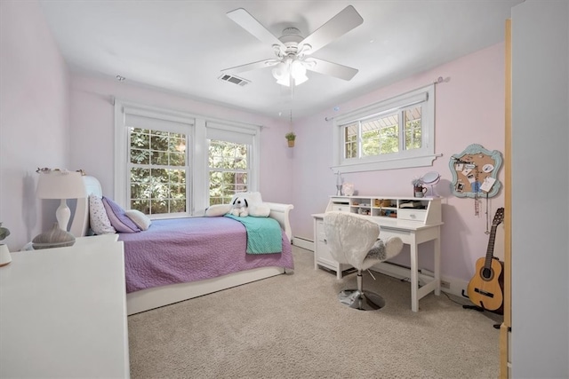 carpeted bedroom with baseboard heating, multiple windows, and ceiling fan