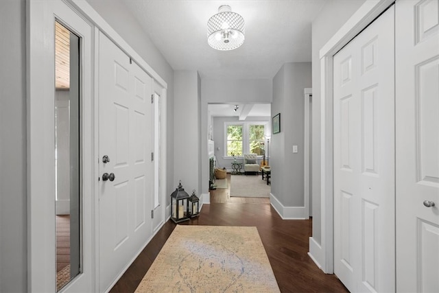 hall featuring a notable chandelier and dark hardwood / wood-style floors