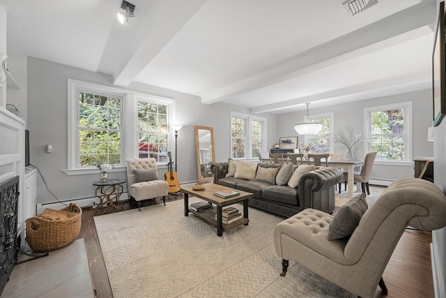 living room with plenty of natural light, light hardwood / wood-style floors, and beam ceiling