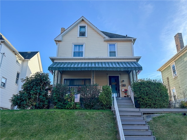 view of front of property with covered porch and a front yard