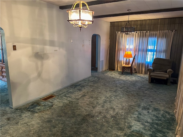 unfurnished room featuring dark colored carpet and beam ceiling