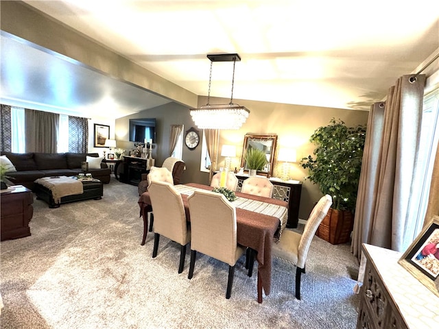 carpeted dining area featuring vaulted ceiling