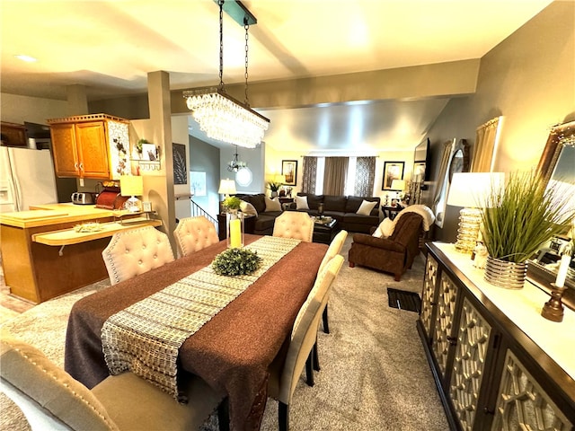 dining area featuring a notable chandelier and light carpet