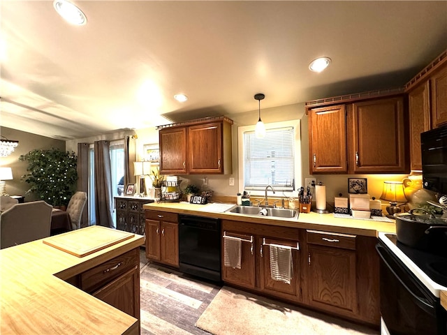 kitchen featuring light hardwood / wood-style floors, black appliances, sink, decorative light fixtures, and butcher block countertops