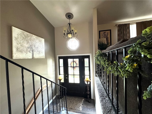 foyer with wood-type flooring, lofted ceiling, and a notable chandelier