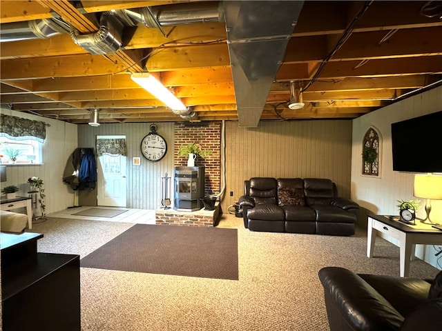 basement with carpet flooring and a wood stove